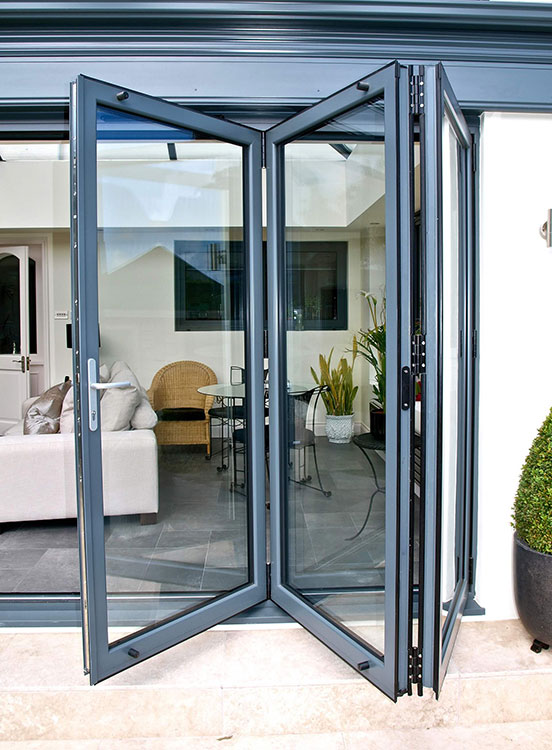 Grey bi-fold doors stacked to the side of a wide opening