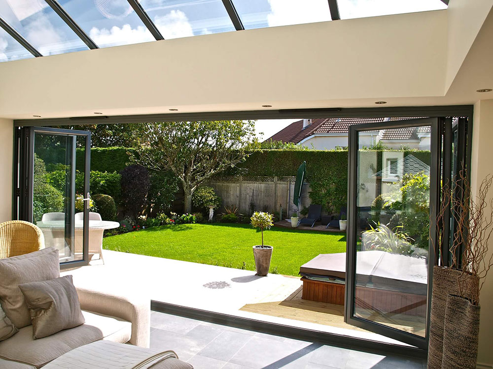Aluminium bi-fold doors fully opened to a garden view