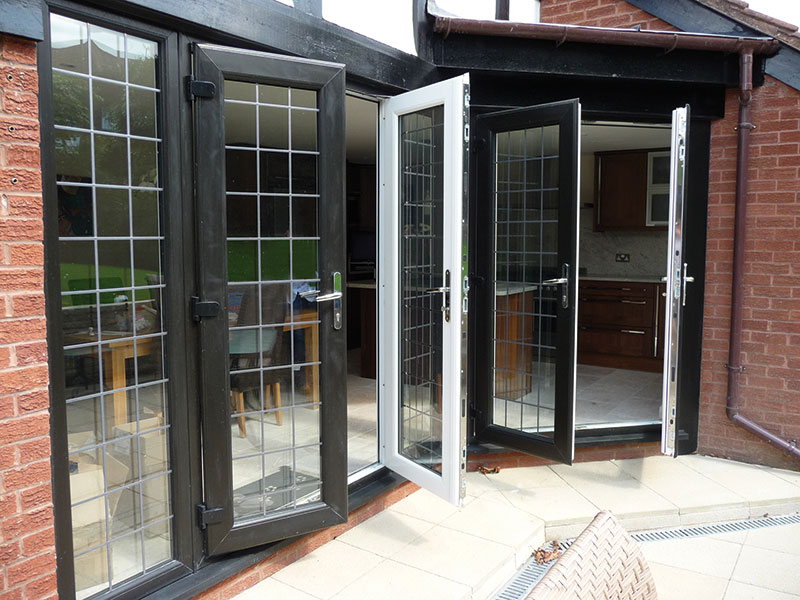 Black aluminium French doors opening onto a patio area