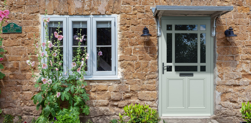 Composite-style entrance door on a stone home exterior representing threshold detailing
